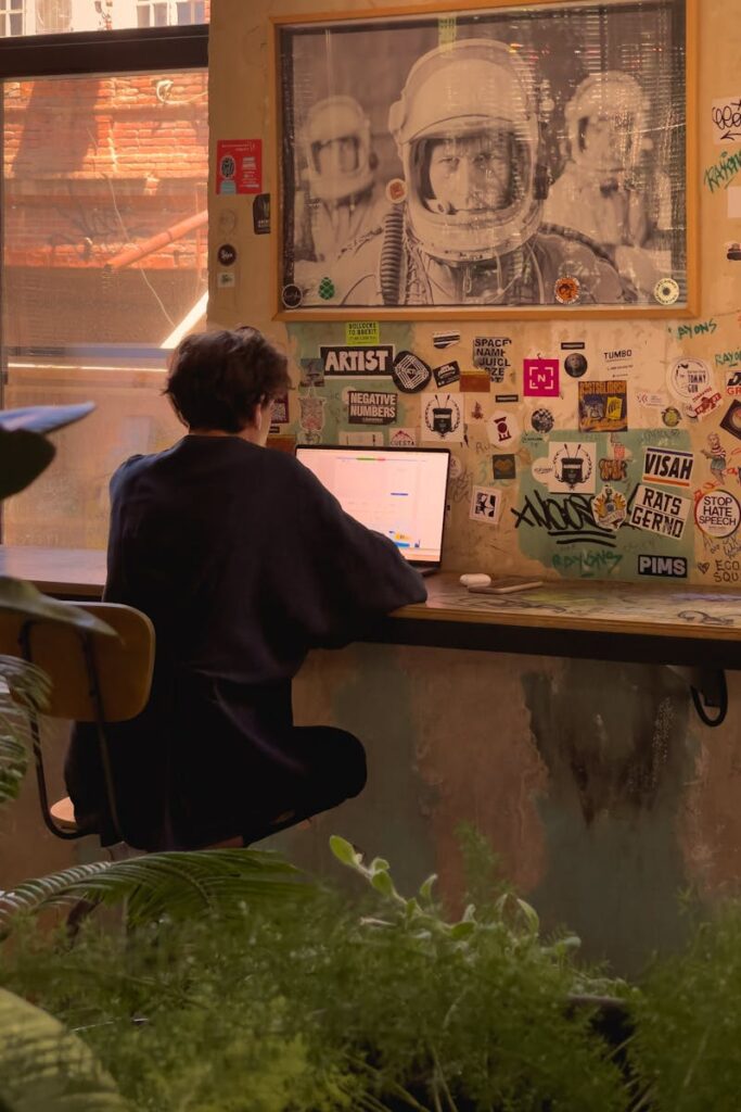 A person sits at a laptop in a decorated indoor space with a warm, cozy vibe in Tbilisi, Georgia.